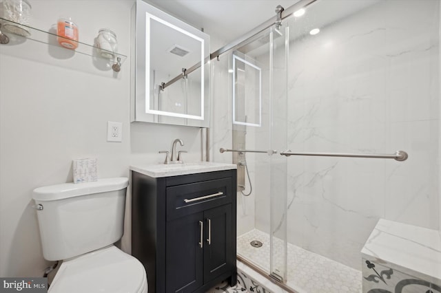 bathroom with a shower with shower door, toilet, and vanity