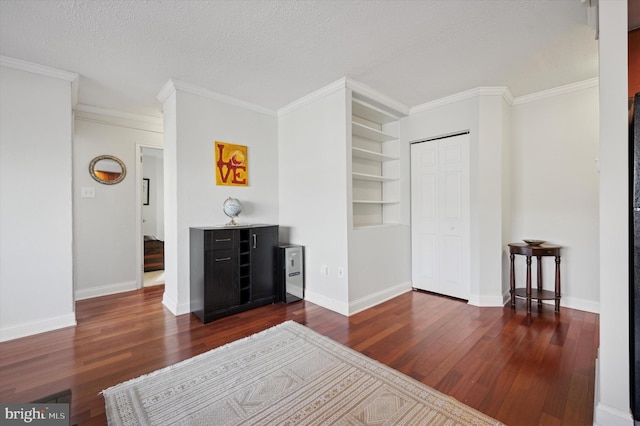 bedroom featuring ornamental molding, a textured ceiling, and wood finished floors