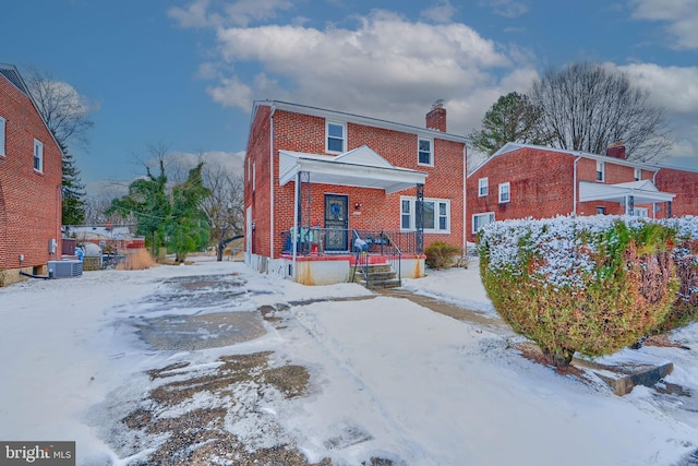 snow covered house with central air condition unit