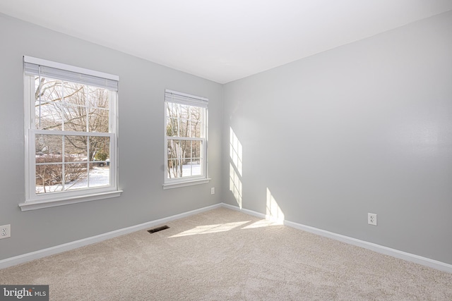 unfurnished room featuring light carpet