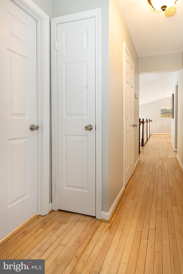 corridor featuring vaulted ceiling and light hardwood / wood-style floors