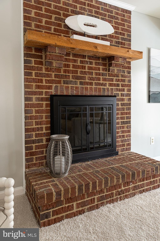 interior details featuring a brick fireplace and carpet flooring