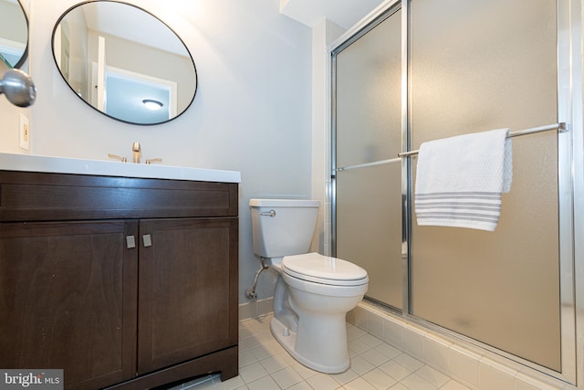 bathroom with vanity, walk in shower, tile patterned floors, and toilet