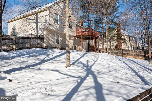 snow covered rear of property featuring a deck