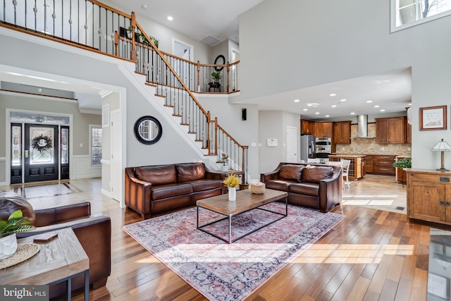 living room with a towering ceiling and light hardwood / wood-style flooring