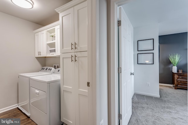 laundry room featuring cabinets, independent washer and dryer, and light colored carpet