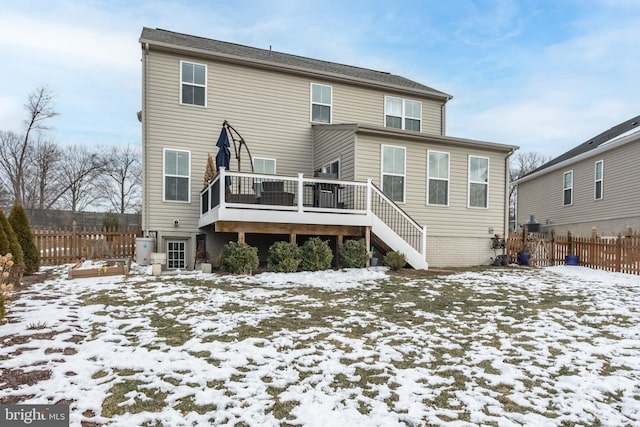 snow covered back of property featuring a deck