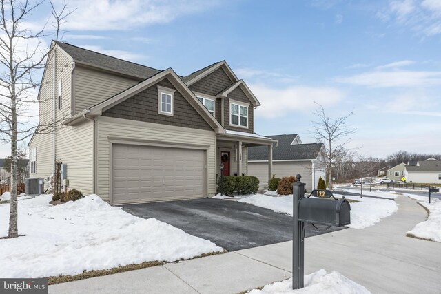 view of front of home with a garage and central AC