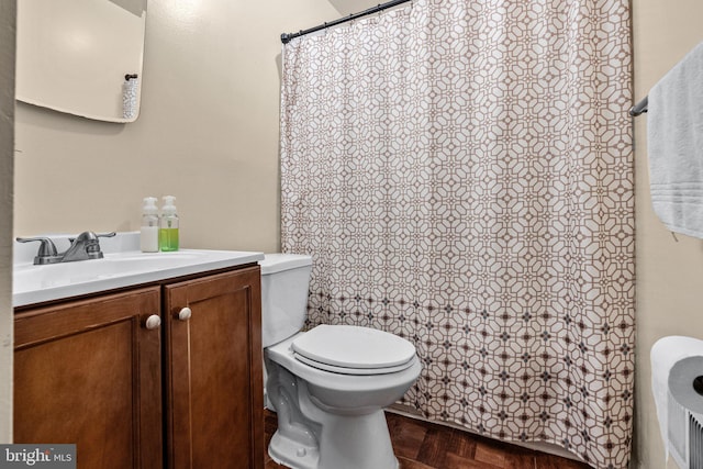 bathroom with toilet, parquet flooring, and vanity