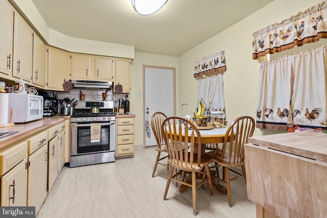 kitchen featuring stainless steel gas stove, backsplash, and cream cabinets