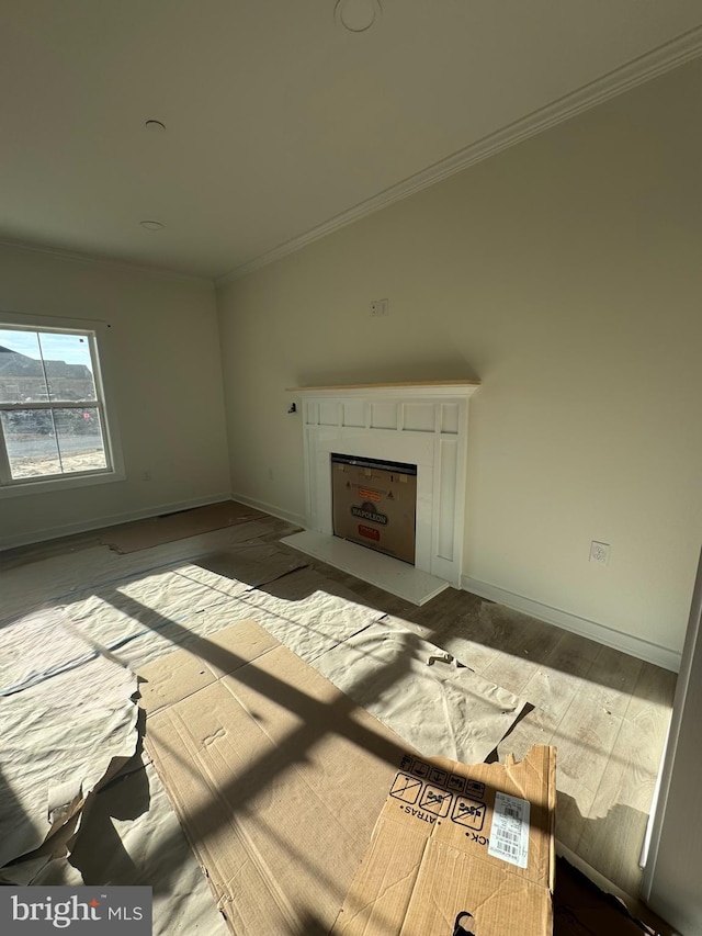 unfurnished living room featuring ornamental molding and hardwood / wood-style floors