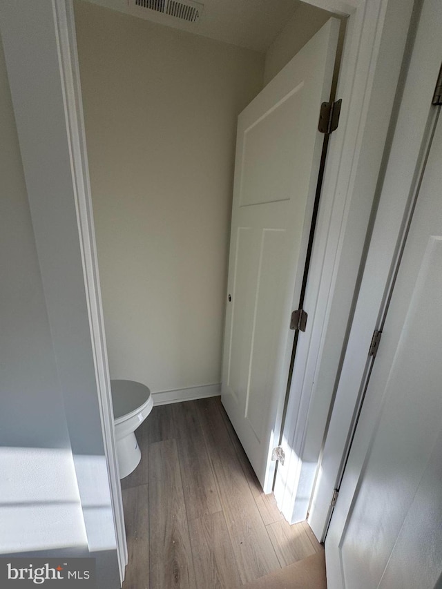 bathroom with hardwood / wood-style flooring and toilet