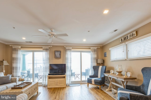 living area with ceiling fan, crown molding, light hardwood / wood-style floors, and plenty of natural light