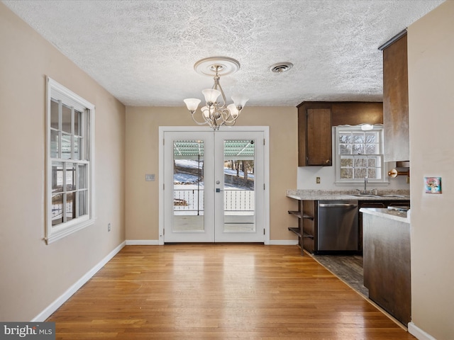 kitchen with light hardwood / wood-style floors, sink, dark brown cabinetry, and stainless steel dishwasher