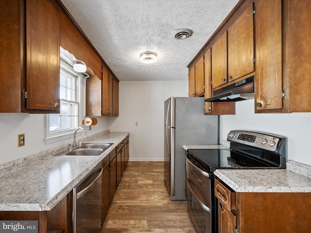 kitchen featuring sink, a textured ceiling, appliances with stainless steel finishes, and dark hardwood / wood-style flooring