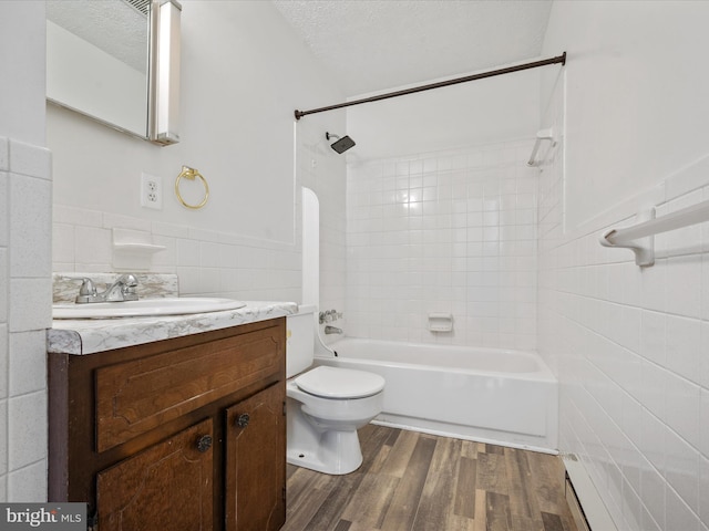 full bathroom with tile walls, tiled shower / bath, hardwood / wood-style floors, a textured ceiling, and vanity