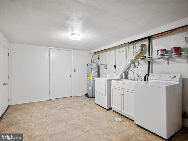 clothes washing area with washing machine and dryer, sink, and water heater