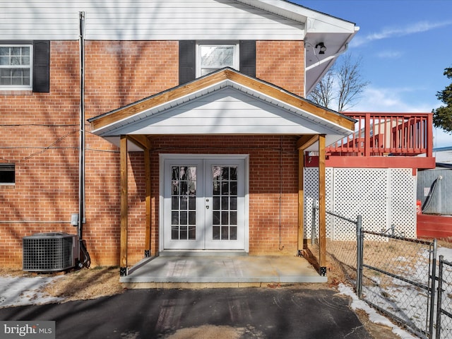 view of exterior entry with central AC unit and french doors