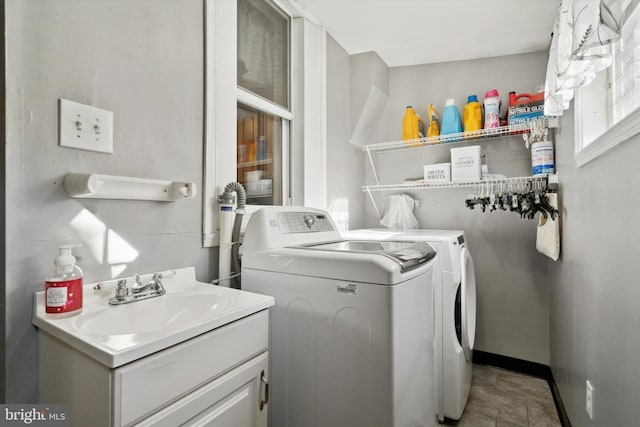 clothes washing area with separate washer and dryer and sink