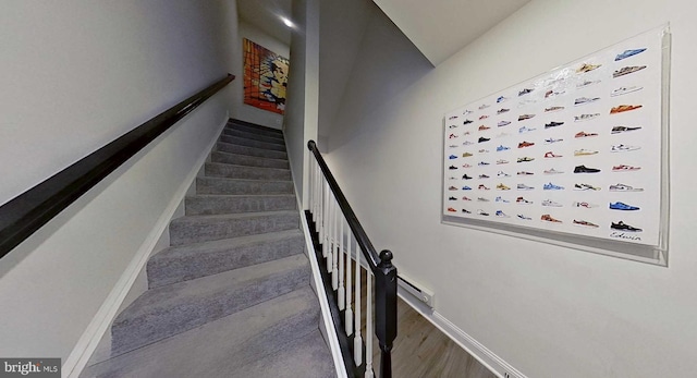 staircase featuring baseboard heating and wood-type flooring