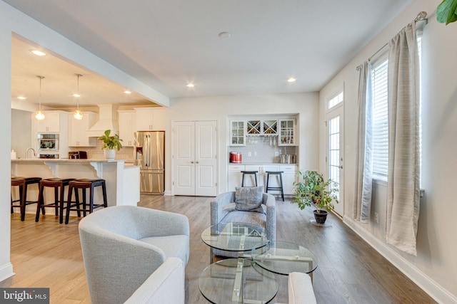 living room featuring wet bar and light hardwood / wood-style floors