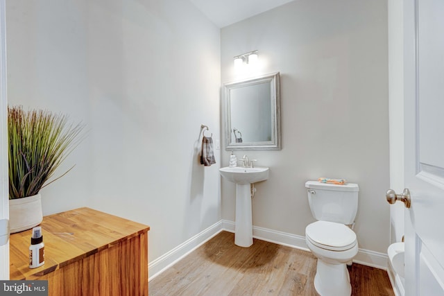 bathroom featuring hardwood / wood-style floors, sink, and toilet