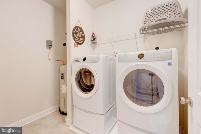 laundry area with light tile patterned floors, washing machine and dryer, and electric water heater