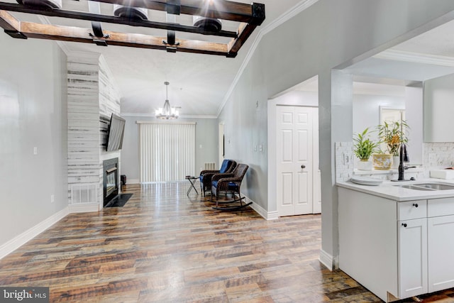 interior space featuring sink, light hardwood / wood-style floors, an inviting chandelier, and ornamental molding