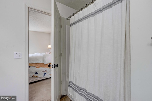 bathroom featuring a textured ceiling and a shower with shower curtain