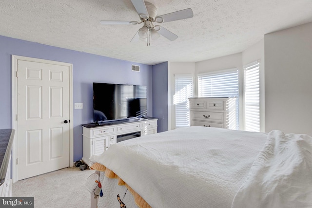 carpeted bedroom with a textured ceiling and ceiling fan