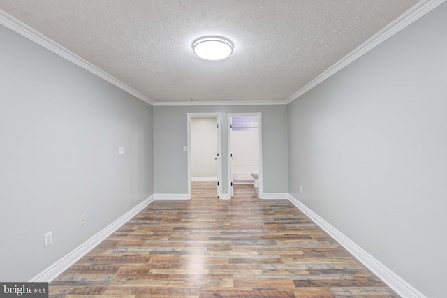 spare room featuring crown molding, light wood-type flooring, and a textured ceiling