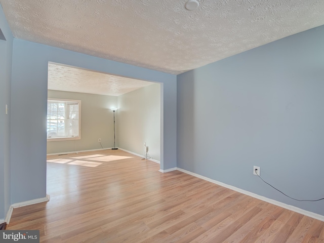 unfurnished room with light hardwood / wood-style floors and a textured ceiling