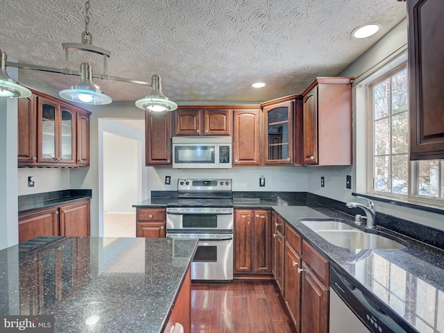 kitchen featuring appliances with stainless steel finishes, a textured ceiling, sink, dark wood-type flooring, and pendant lighting