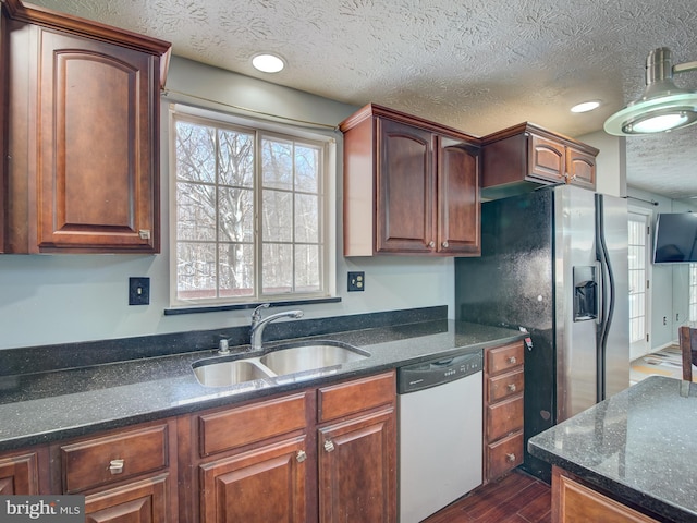 kitchen featuring sink, dishwasher, dark wood-type flooring, and a textured ceiling