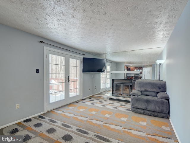 living room featuring french doors, a wealth of natural light, and a textured ceiling