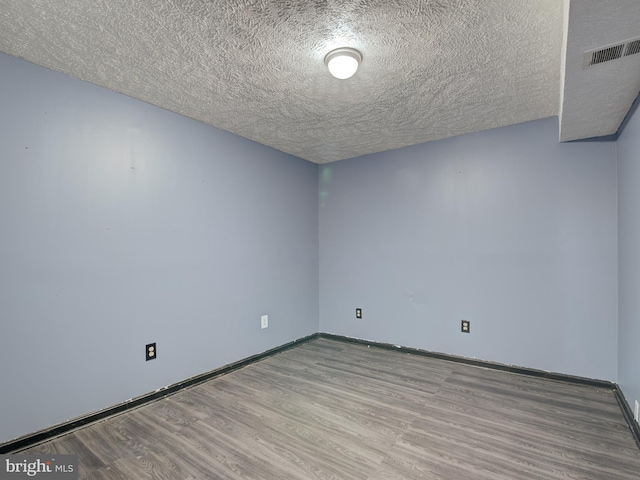 empty room with light hardwood / wood-style flooring and a textured ceiling