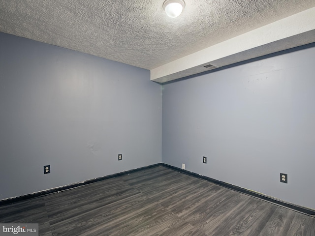 unfurnished room featuring a textured ceiling and dark hardwood / wood-style floors