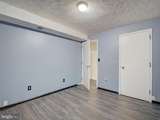 unfurnished bedroom with a textured ceiling and hardwood / wood-style floors