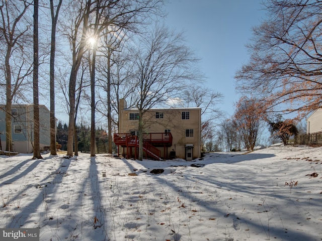 snow covered rear of property featuring a deck