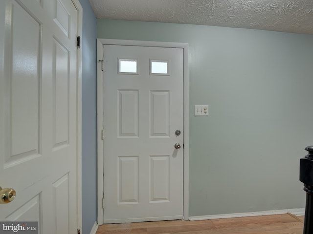 entrance foyer featuring a textured ceiling and light hardwood / wood-style flooring