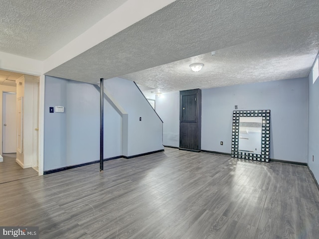 basement featuring a textured ceiling and wood-type flooring