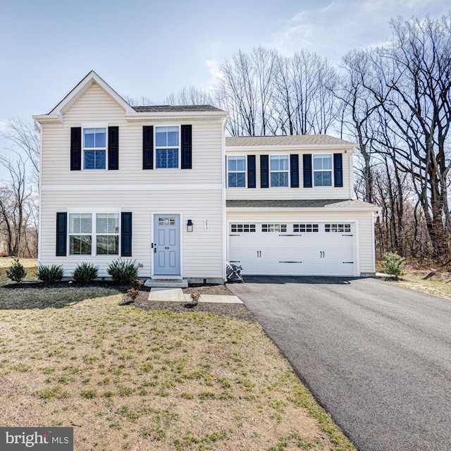 view of front facade featuring a garage, a front lawn, and driveway