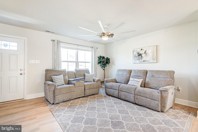 living room with visible vents, baseboards, a ceiling fan, and wood finished floors