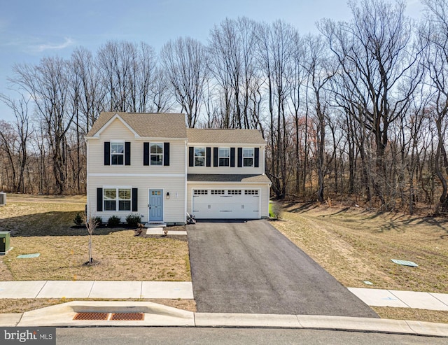 view of front of house featuring a front yard, an attached garage, and aphalt driveway