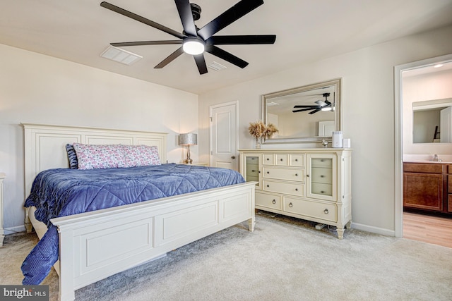 bedroom with ensuite bath, carpet flooring, visible vents, and ceiling fan