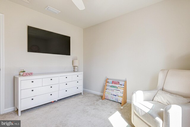 sitting room featuring visible vents, light carpet, baseboards, and a ceiling fan