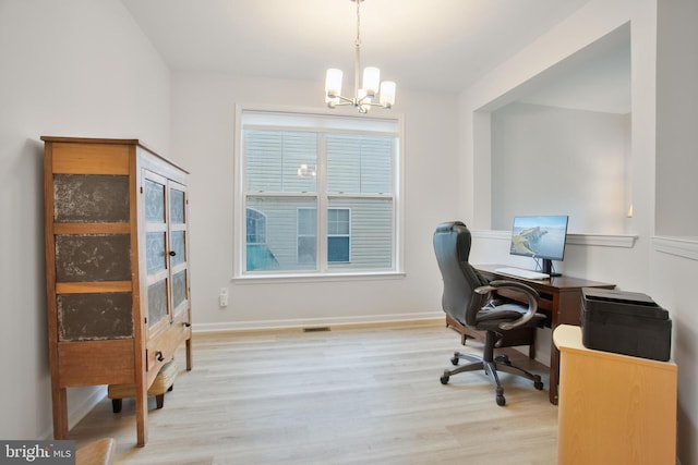 home office with an inviting chandelier and light wood-type flooring