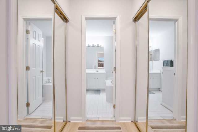 corridor with sink and light tile patterned floors