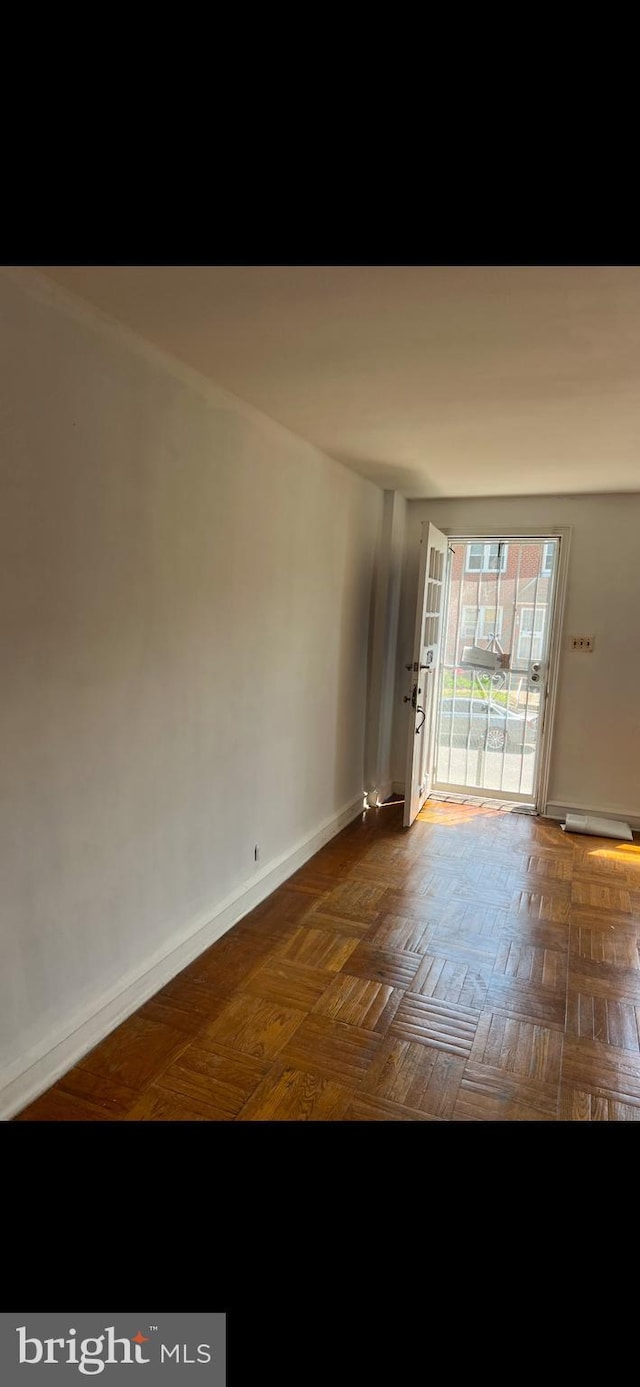 spare room featuring dark parquet flooring