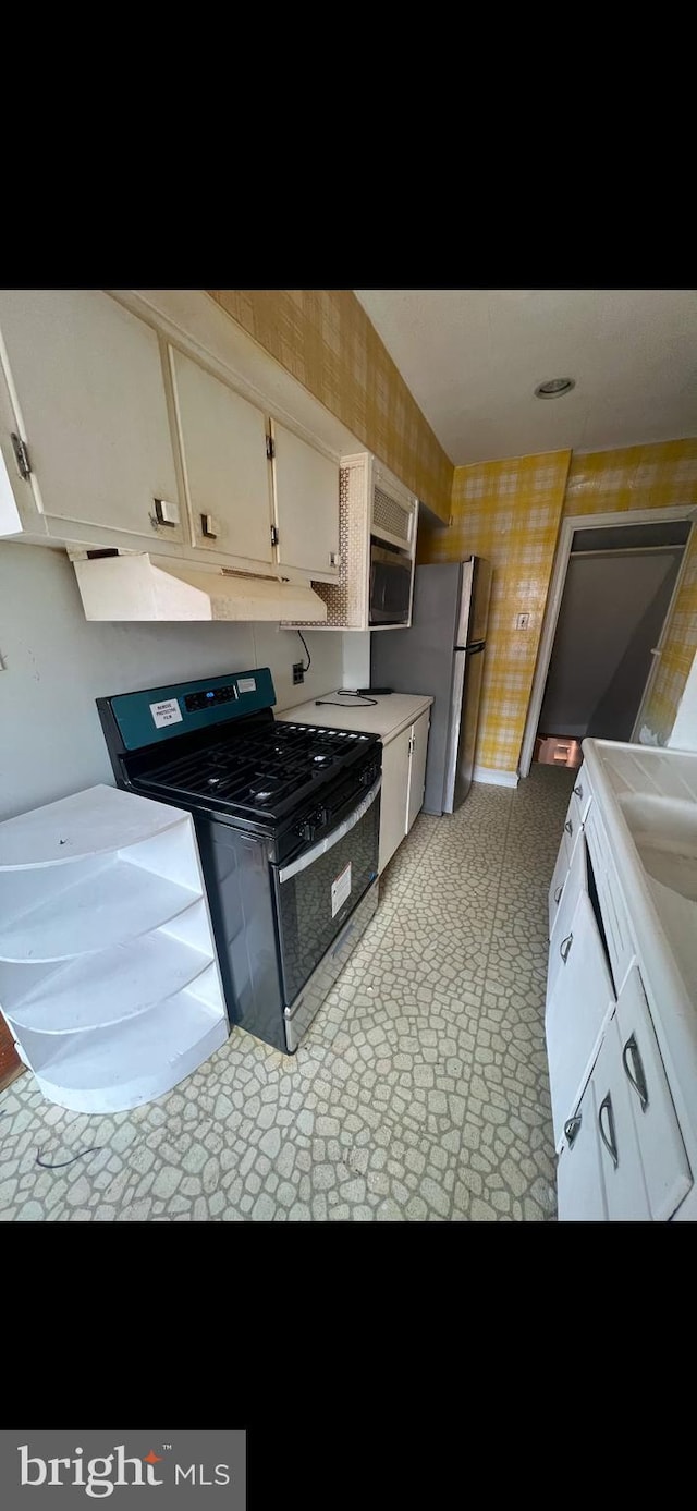 kitchen with appliances with stainless steel finishes and white cabinetry